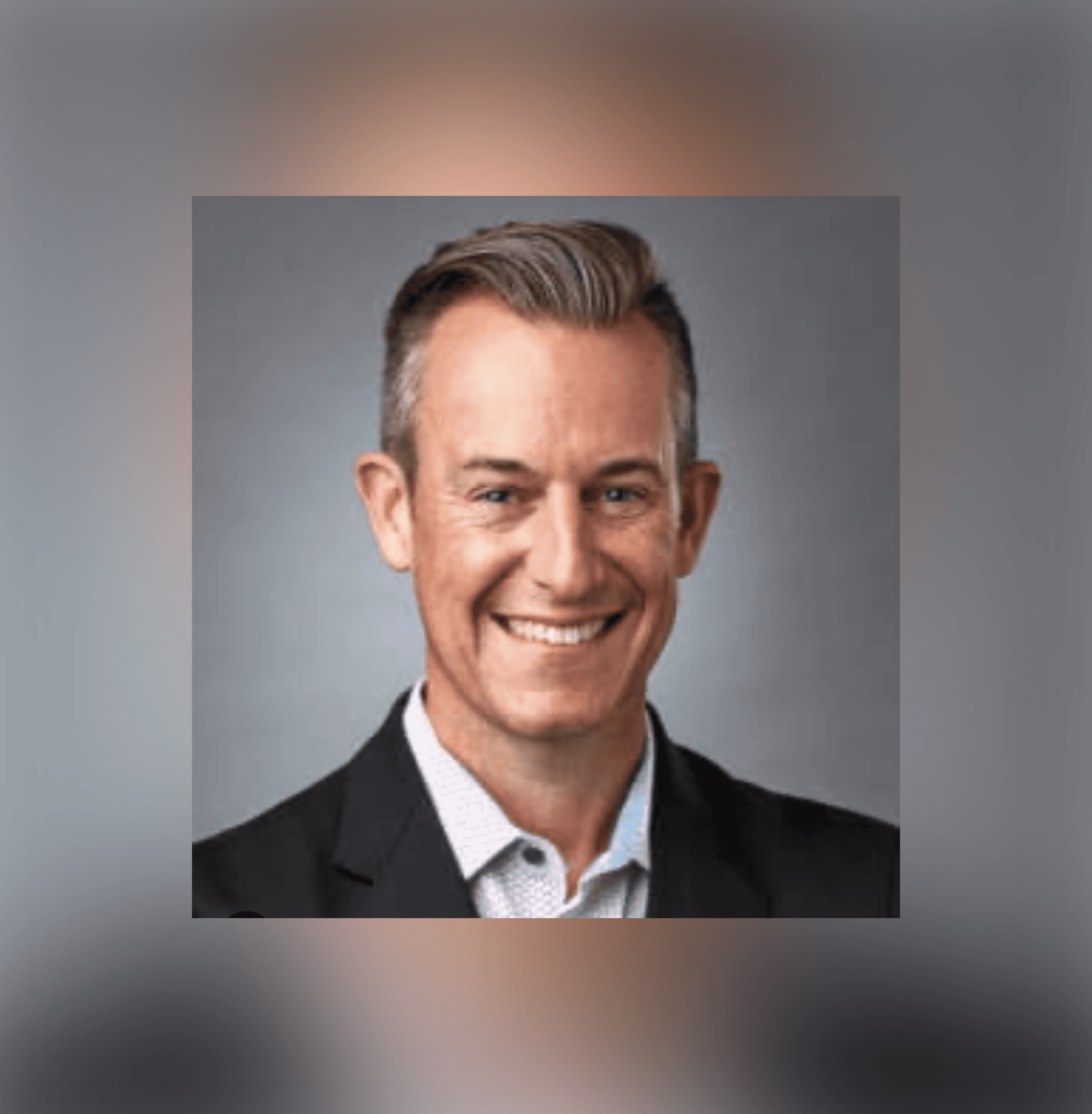 Headshot of a smiling person in a dark blazer