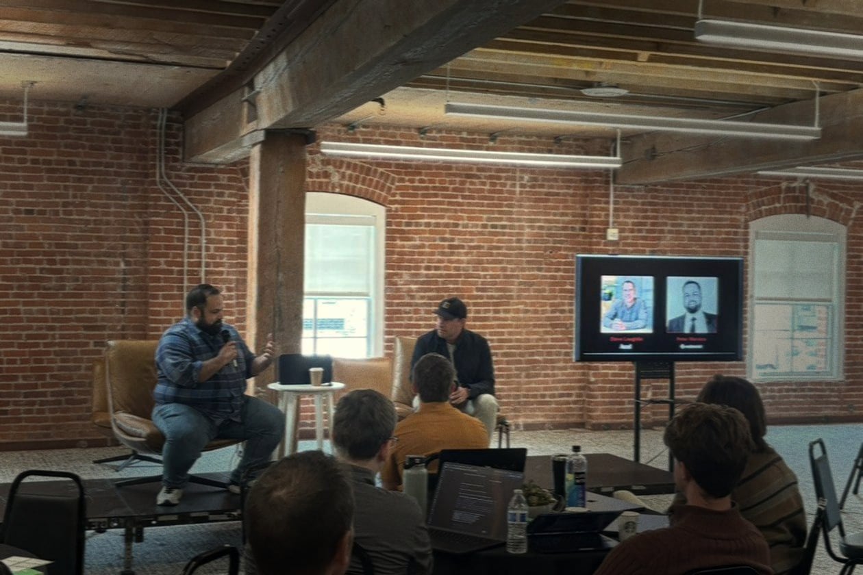 Two speakers in a fireside chat on stage at a Code Metal event